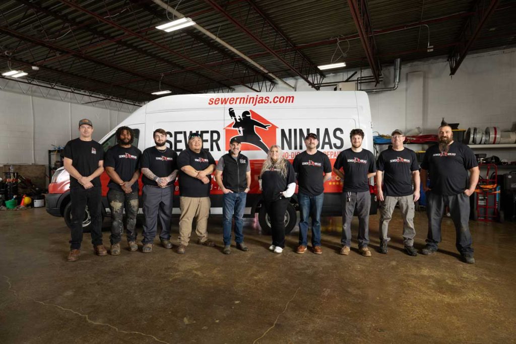 Sewer Ninjas team standing in front of a company van