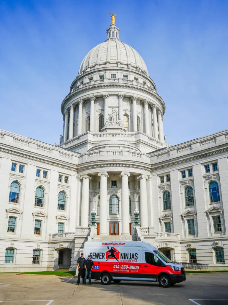 Joe walsh and jordan lemanski standing in front of a sewer ninjas company van parked next to Madison capitol building in Wisconsin.