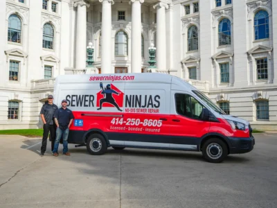Joe walsh and jordan lemanski standing in front of a sewer ninjas company van parked next to Madison capitol building in Wisconsin.
